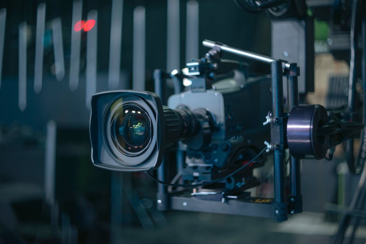 A cinematic camera and lens held on a gimbal in dramatic low light