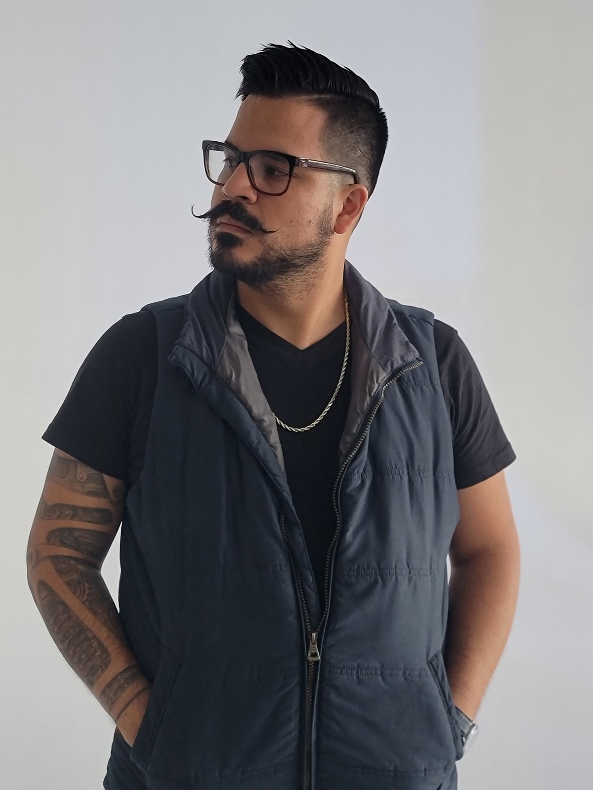 Javier Chavarro — videographer, editor, and creative producer at Javnio — in a black t-shirt and gray puffer vest